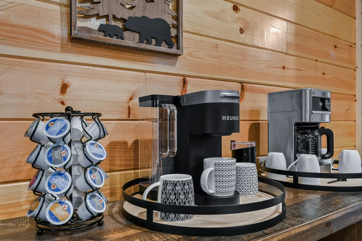 A dedicated coffee station featuring a Keurig coffee maker, a pod holder, and accent wall decor, creating a homey spot for morning rituals and relaxed conversation.